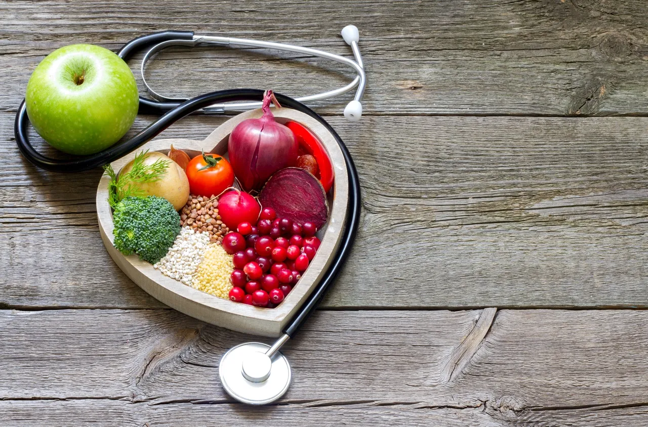 Heart-shaped tray of healthy foods and stethoscope.