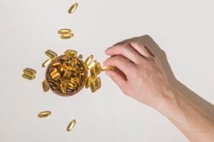 Hand picking omega-3 capsules from bowl
