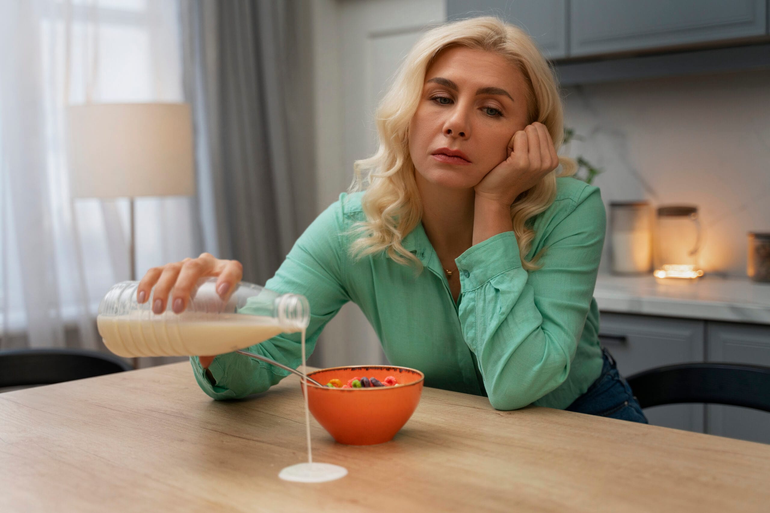 Woman accidentally spills milk while pouring cereal.