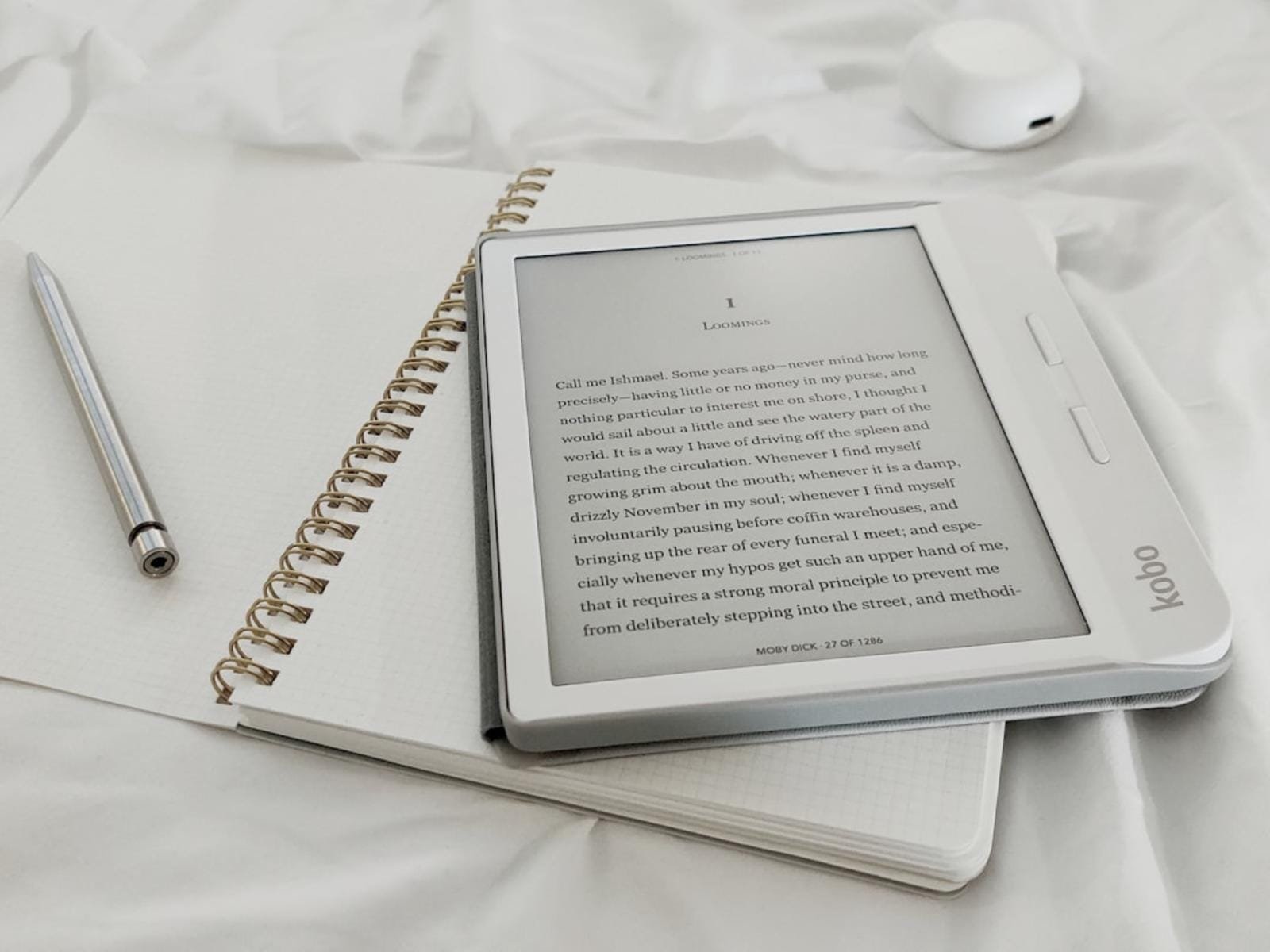 E-reader on notebook with pen, minimalistic setting.