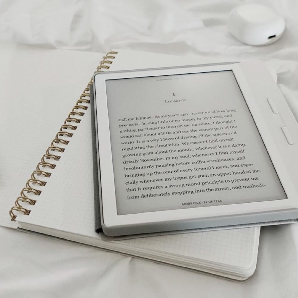 E-reader on notebook with pen, minimalistic setting.