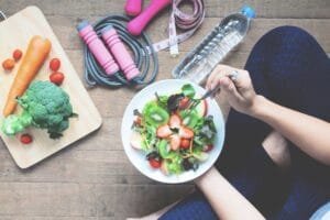 Healthy lifestyle: salad, dumbbells, vegetables, and water