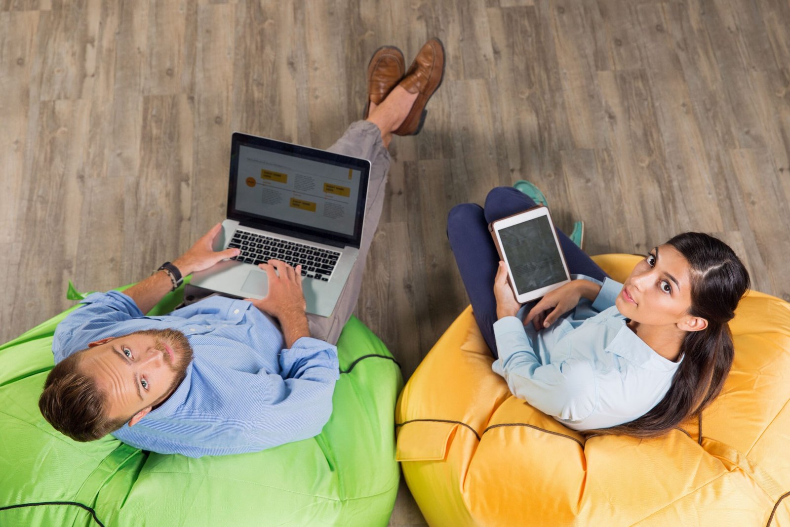 Two people working on laptop and tablet.